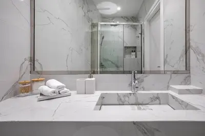 a white bathroom with a sink and a shower at Acropolis Museum Apartment by A&A Residences in Athens