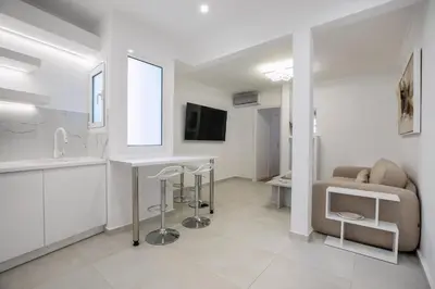 a kitchen and living room with a table and a couch at Acropolis Museum Apartment by A&A Residences in Athens