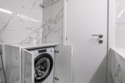 a washer and dryer in a white bathroom at Acropolis Museum Apartment by A&A Residences in Athens