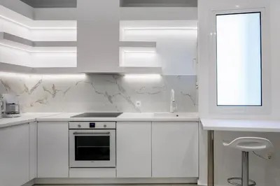 a white kitchen with white cabinets and a window at Acropolis Museum Apartment by A&A Residences in Athens