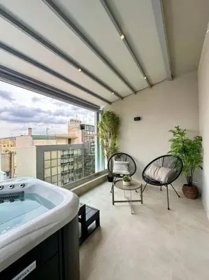 a bathroom with a tub and chairs on a balcony at BlueMotion - SensaBlu in Piraeus
