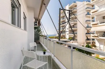 a balcony with chairs and a table on a building at Alimos Seabreeze apartment in Athens