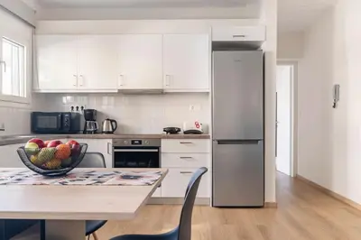 a kitchen with a table with a bowl of fruit on it at Alimos Seabreeze apartment in Athens