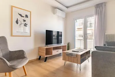 a living room with a couch and a tv at Alimos Seabreeze apartment in Athens