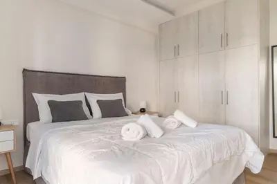 a white bed with white pillows on top of it at Alimos Seabreeze apartment in Athens