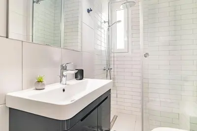 a white bathroom with a sink and a shower at Alimos Seabreeze apartment in Athens