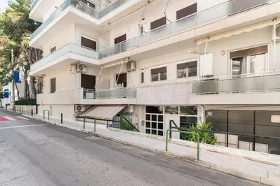 an empty street in front of a white building at Alimos Seabreeze apartment in Athens