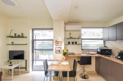 a kitchen with a wooden table and chairs at Aiolos GLYFADA luxury apartment in Athens
