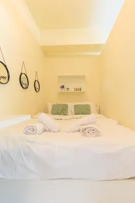 a white bedroom with a large white bed at Aiolos GLYFADA luxury apartment in Athens