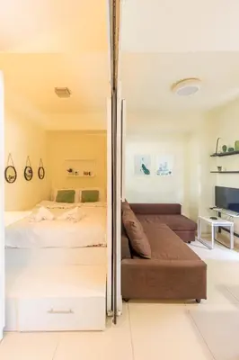 a bedroom with a bed and a couch at Aiolos GLYFADA luxury apartment in Athens