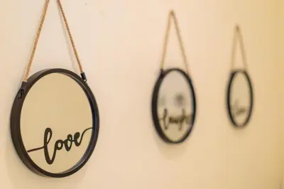 two mirrors hanging on a wall with the words love at Aiolos GLYFADA luxury apartment in Athens