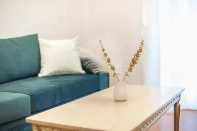 a living room with a couch and a vase on a table at Golden Comfort With Courtyard By Greece Apartments in Athens