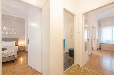 a white bedroom with a bed and a hallway at Golden Comfort With Courtyard By Greece Apartments in Athens