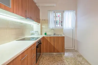 a kitchen with wooden cabinets and a sink and a window at Golden Comfort With Courtyard By Greece Apartments in Athens