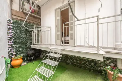 a balcony with two white chairs on the grass at Golden Comfort With Courtyard By Greece Apartments in Athens