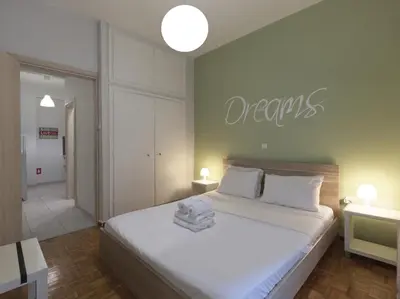 a bedroom with a bed with a sign that reads dreams at Cozy Athenian One BD, Pistachio Charm in Athens