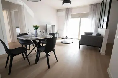 a dining table and chairs in a living room at Modern 7th-floor apartment with city view (FORM_G2) in Athens