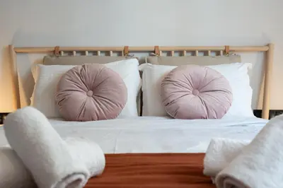 a bed with two pink pillows on it at LIV - Modern Heavenly Retreat in Exarcheia in Athens