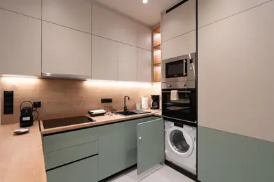 a kitchen with white cabinets and a washer and dryer at LIV - Modern Heavenly Retreat in Exarcheia in Athens