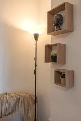 a floor lamp in a room with a head on a wall at Minimal and cozy Home in Zografou in Athens