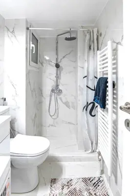 a white bathroom with a shower and a toilet at Minimal and cozy Home in Zografou in Athens
