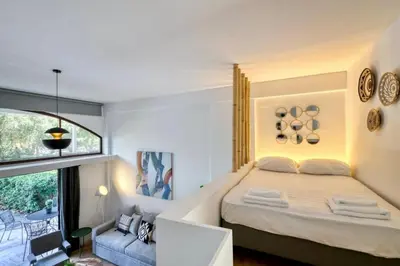 a bedroom with a large bed and a window at The Four Seasons Vouliagmeni Escape in Athens
