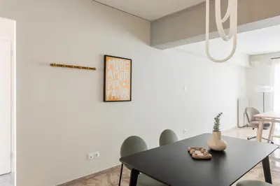 a dining room with a black table and green chairs at Exclusive 2BR Apartment in Alimos by UPSTREET in Athens