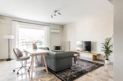 a living room with a couch and a table at Exclusive 2BR Apartment in Alimos by UPSTREET in Athens
