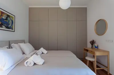 a bedroom with two beds and a table and a mirror at Heart of Athens - Hidden Gem - Elegant 2 Bedroom Flat in Athens