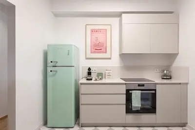 a kitchen with a green refrigerator and white cabinets at Heart of Athens - Hidden Gem - Elegant 2 Bedroom Flat in Athens