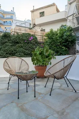 two chairs and a table and a potted plant at Heart of Athens - Hidden Gem - Elegant 2 Bedroom Flat in Athens