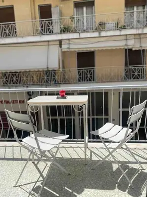 two chairs and a table in front of a building at 130m Luxury apartment in the heart of Athens in Athens