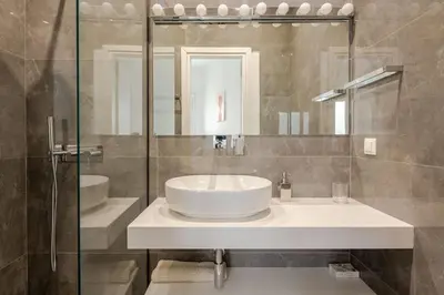 a bathroom with a white sink and a mirror at 130m Luxury apartment in the heart of Athens in Athens
