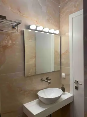 a bathroom with a white sink and a mirror at 130m Luxury apartment in the heart of Athens in Athens