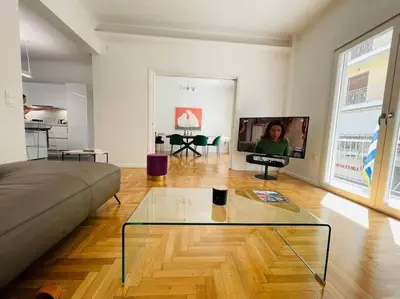 a living room with a couch and a glass table at 130m Luxury apartment in the heart of Athens in Athens