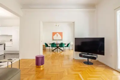 a living room with a large television and a table at 130m Luxury apartment in the heart of Athens in Athens