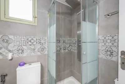 a bathroom with a toilet and a glass shower at Διαμέρισμα με πισίνα στην Αρτέμιδα in Vravrona