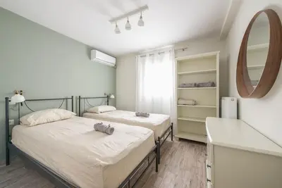 two beds in a room with a mirror at Διαμέρισμα με πισίνα στην Αρτέμιδα in Vravrona