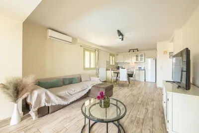 a living room with a couch and a table at Διαμέρισμα με πισίνα στην Αρτέμιδα in Vravrona