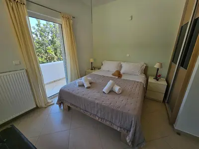 a bedroom with a bed with a teddy bear on it at Zoe's home - stunning view in Áyios Konstandínos