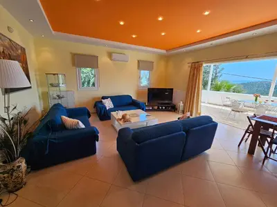 a living room with two blue couches and a table at Zoe's home - stunning view in Áyios Konstandínos