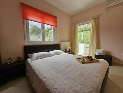 a bedroom with a large bed and a large window at Zoe's home - stunning view in Áyios Konstandínos
