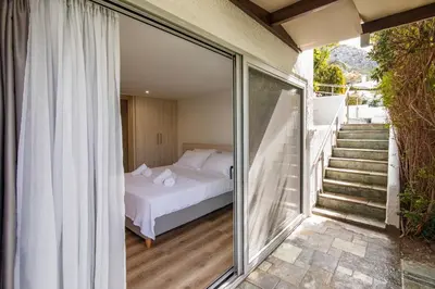a bedroom with a bed and sliding glass doors at Astarte Sunset Villa in Sounio