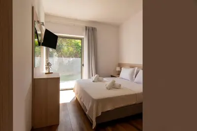 a bedroom with a bed and a large window at Astarte Sunset Villa in Sounio