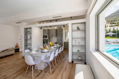 a dining room and kitchen with a table and chairs at Astarte Sunset Villa in Sounio