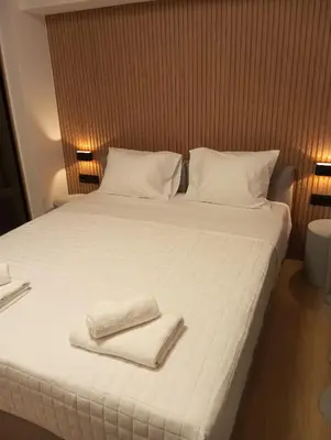 a large white bed with two towels on it at BlueMotion -PortStay N1 in Piraeus