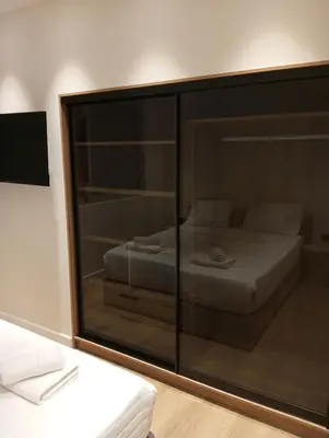 a bedroom with a glass partition with a bed in it at BlueMotion -PortStay N1 in Piraeus