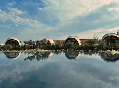 two domed buildings with their reflections in the water at 91 Athens Riviera, The Resort in Athens