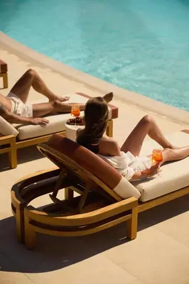 two women laying on lounge chairs by a pool at 91 Athens Riviera, The Resort in Athens