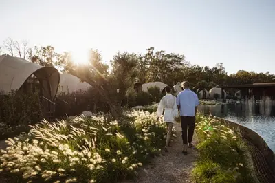 a man and woman walking down a path by the water at 91 Athens Riviera, The Resort in Athens